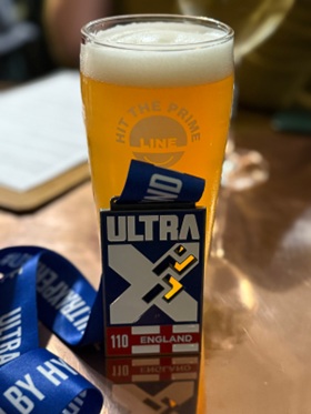A pint of beer with a medal from the Ultra X England event