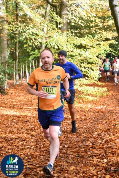 Matt running with others in an autumn woodland